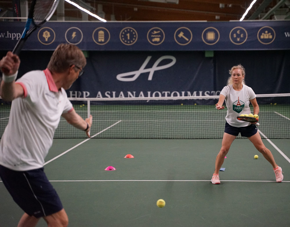 Emma Laine valmentaa tennistä Talin Tenniskeskuksessa.